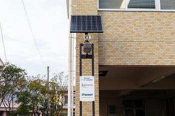 東日本大震災をきっかけに自社開発した蓄電池内蔵型「太陽光発電街路灯」。 非常時にUSBやコンセントが使用できる。太陽光発電無しで5日間の点灯が可能