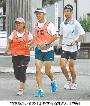 視覚障害者の伴走をする酒井さん(中央)