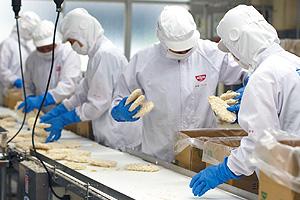 トンカツを箱詰めする作業員=本社工場
