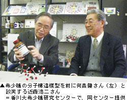 ▲希少糖の分子構造模型を前に何森 健さん（左）と談笑する近藤浩二さん ＝香川大学希少糖研究センターで、同センター提供