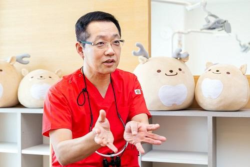 伸治院長の後ろに写るのは、医院のキャラクター「しーかーさん」