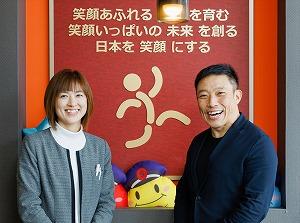 本社にて。Group企業理念「笑顔あふれるヒトを育む 笑顔いっぱいの未来を創る 日本を笑顔にする」
